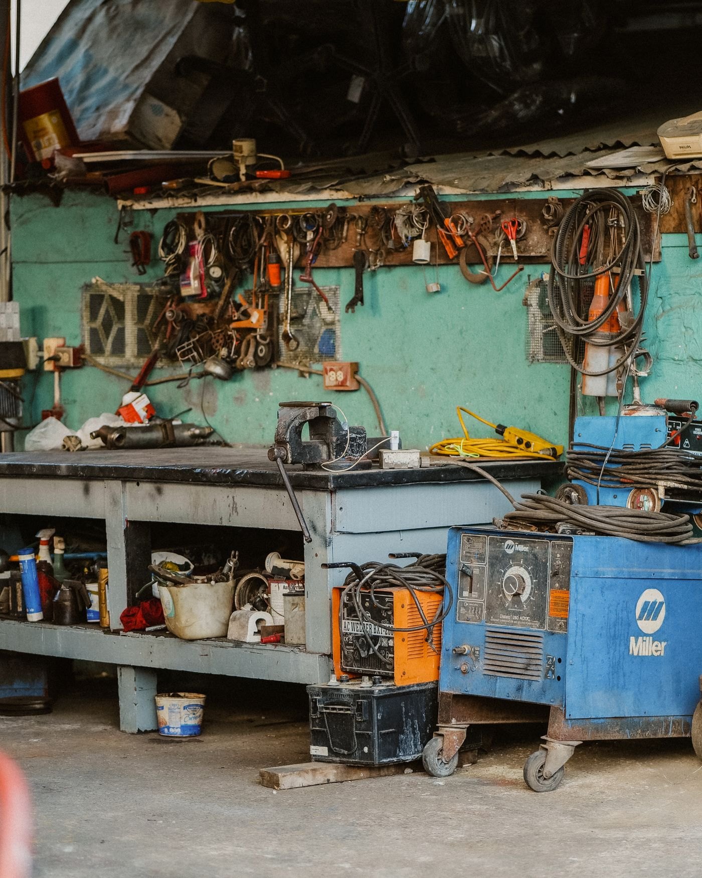 Welding shop bench with welders and hanging tools